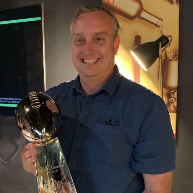 Boyd Wilson posing with the Vince Lombardi trophy.