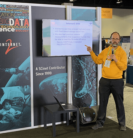 Igor in SC19 Booth presenting on Characterizing Networking In and Out of the Clouds.