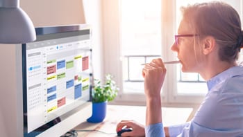 Image illustrating a woman looking at a calendar for Community Partner Events