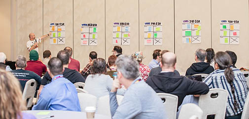 A man points to a sticky note to a board at a recent conference.